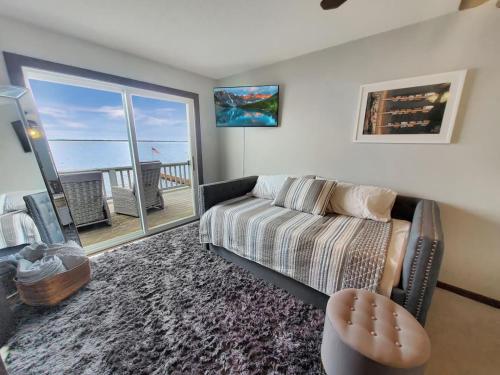 a living room with a couch and a view of the ocean at Unsalted Shores on Big Spirit Lake in Orleans
