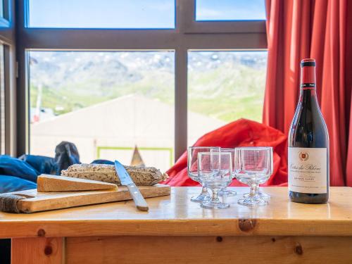 a bottle of wine and two glasses on a table at Apartment Eskival 106 by Interhome in Val Thorens