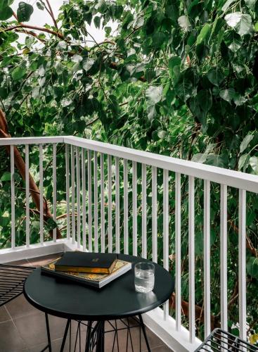 a table on a balcony with a book on it at The StandardX, Bangkok Phra Arthit in Bangkok