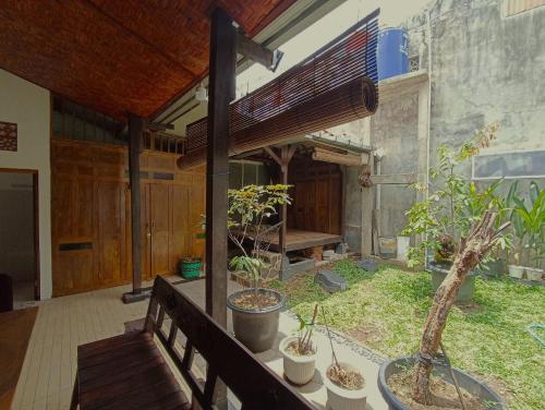 NgabeanにあるOmah Adem Homestayの木製の柵の上に鉢植えの植物があるパティオ