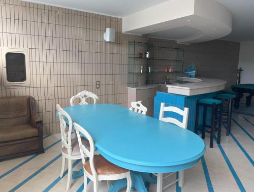 a blue table and chairs in a room with a kitchen at Casa da Avó Ilda - Angeiras Beach House in Lavra