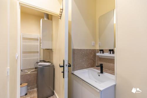une salle de bain avec un lavabo et un miroir dans l'établissement MBA - Boulangers Splendide Appartement, à Paris