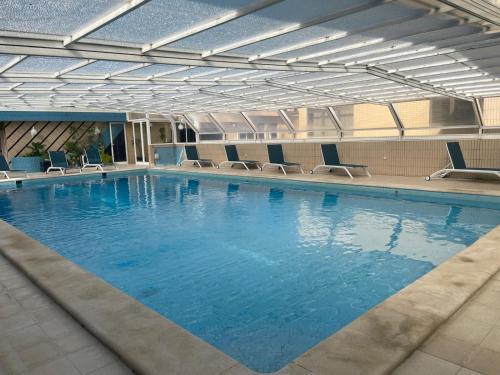 a large swimming pool with chairs in a building at Casa da Avó Ilda - Angeiras Beach House in Lavra