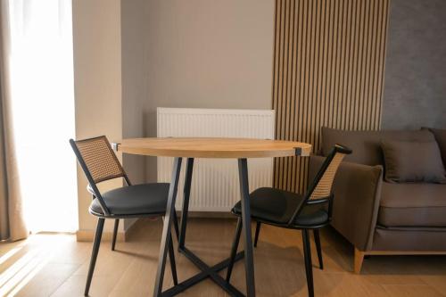 a table and chairs in a room with a couch at Luxury Central Apartment 4,2 in Larisa