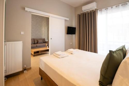 a bedroom with a large white bed and a couch at Luxury Central Apartment 4,2 in Larisa