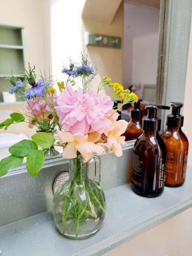 a vase filled with flowers sitting on a bathroom counter at Porcupine Hills Olive and Guest Farm in Botrivier
