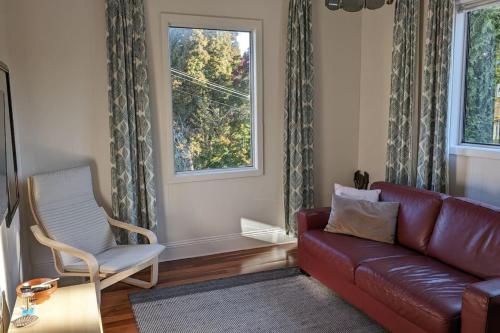 Una sala de estar con un sofá y una silla y una ventana. en Alkira Cottage - Cozy, Comfortable, and Convenient, en Katoomba