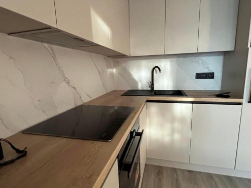 a kitchen with a sink and white cabinets at Apartments Martino in Olomouc