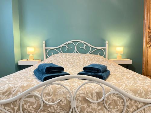 une chambre avec un lit avec des serviettes bleues dessus dans l'établissement Family's Home, à Bayeux