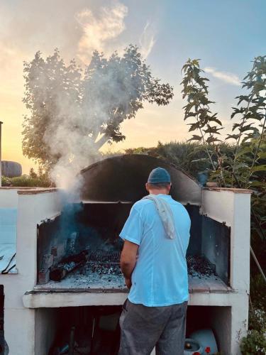 a man standing in front of a barbecue grill at Agriturismo Campallegro in Cecina