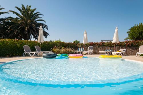 a large swimming pool with chairs and umbrellas at Agriturismo Campallegro in Cecina