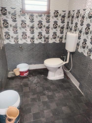 a bathroom with a toilet and a sink in it at Sri Krishna's AC in Tiruvannāmalai