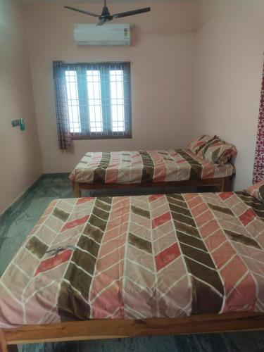 a bedroom with two beds and a window at Sri Krishna's AC in Tiruvannāmalai