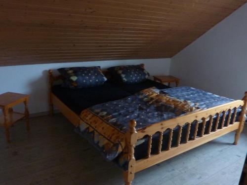 1 dormitorio con 1 cama de madera y 2 mesas en Ferienwohnung Schildwache, en Homburg