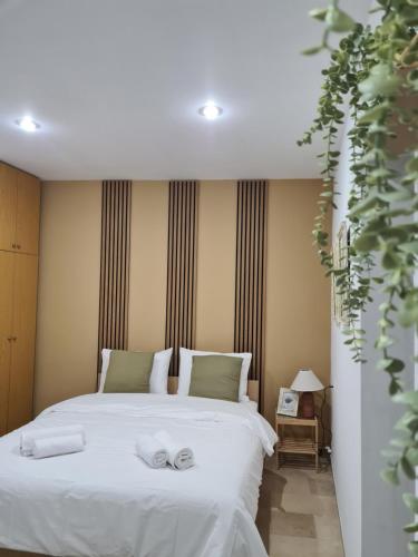 ein Schlafzimmer mit einem weißen Bett mit Handtüchern darauf in der Unterkunft Apartment in the heart of the city 5G in Larisa