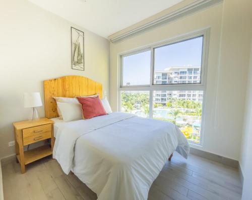 a bedroom with a white bed and a large window at Ventanas del Mar by Playa Caracol 3 Habitaciones in Punta Chame