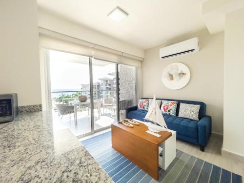 a living room with a blue couch and a table at Ventanas del Mar by Playa Caracol 3 Habitaciones in Punta Chame