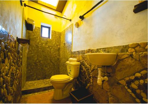 bagno in pietra con servizi igienici e lavandino di TITIKAKA NATURAL LODGE - LUQUINA a Chucuito