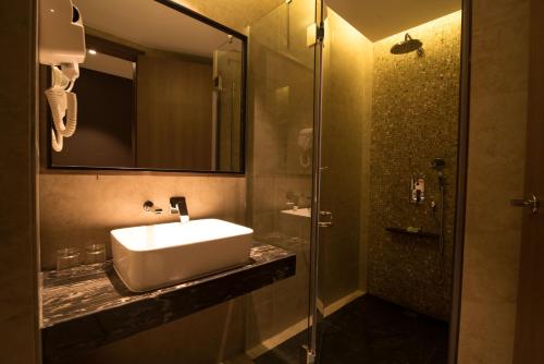 ein Bad mit einem Waschbecken und einer Dusche in der Unterkunft ESKA Hotel in Batam Center