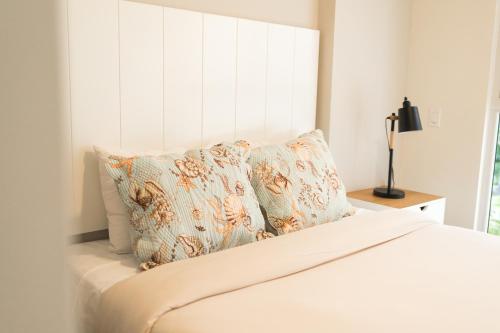 a white bed with pillows and a window at Ventanas del Mar by Playa Caracol 3 Habitaciones in Punta Chame