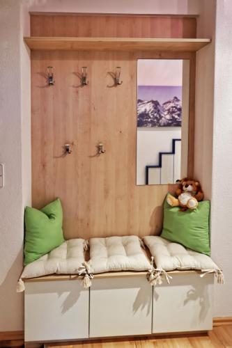 a couch with green pillows and a picture on the wall at Appartements-Klaus in Neustift im Stubaital