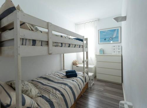 a bedroom with a bunk bed and a bedroom with a dresser at Es Racó Blau in Cadaqués