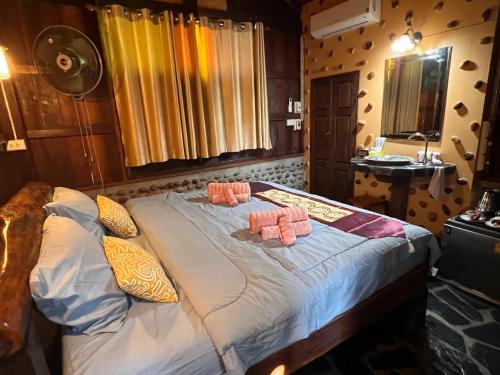 a bedroom with a bed with two pillows on it at Riverside Retreat Sukhothai Guest House in Sukhothai
