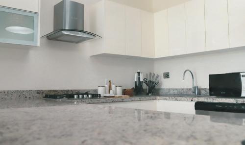 a kitchen with white cabinets and a stainless steel sink at Sanctuary by Playa Caracol Frente al Mar in Punta Chame