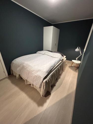 a bedroom with a large bed and a lamp at Eide Aurora Apartement in Tromsø