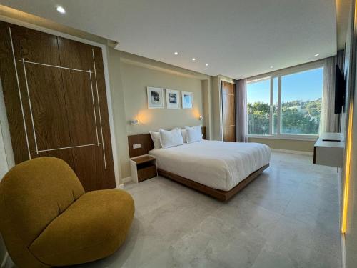 Un dormitorio con una cama y una silla y una ventana. en R&S Marina Bay Tanger Marsa, en Tánger