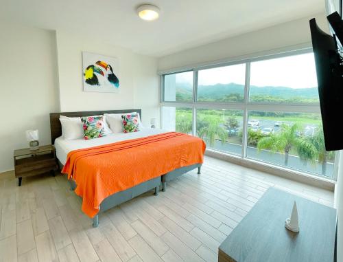a bedroom with a bed and a large window at Sanctuary by Playa Caracol Frente al Mar in Punta Chame