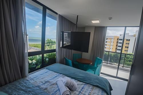 a bedroom with a bed and a large window at Condomínio Ozean - Bessa in Tambaú