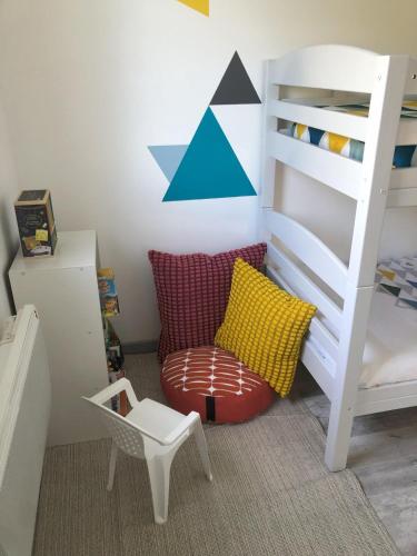 a childs bedroom with a bunk bed and a chair at Tri-O-Bois in Thianges