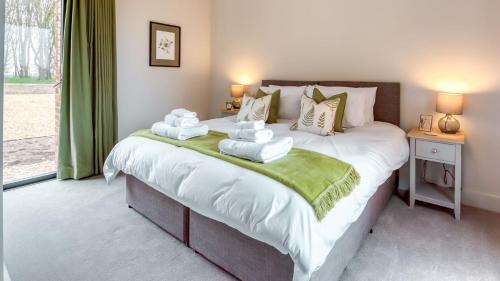 a bedroom with a large bed with towels on it at Downs in Blewbury