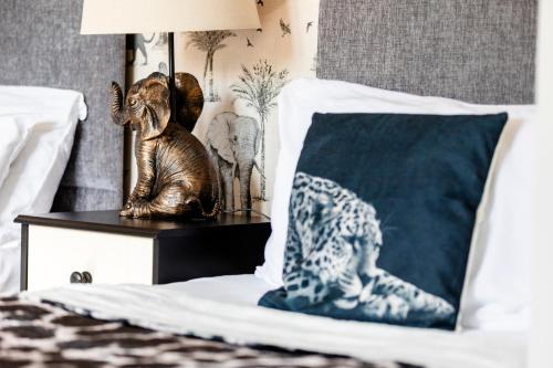 a statue of an elephant on a night stand next to a bed at Jungle House in Chichester