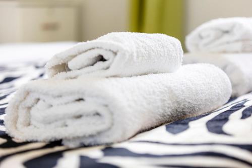 a pile of towels sitting on top of a bed at Jungle House in Chichester