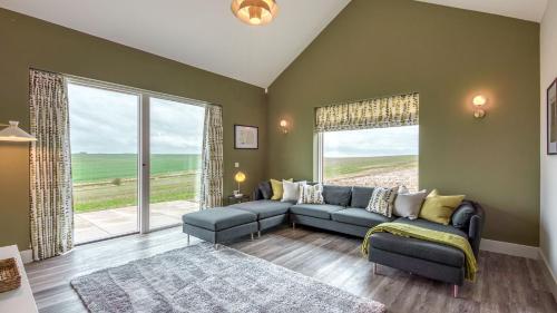 a living room with a couch and a large window at Downs in Blewbury