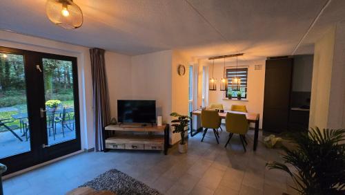 a living room with a television and a dining room at Vakantiewoning Maas en Waal in Ewijk