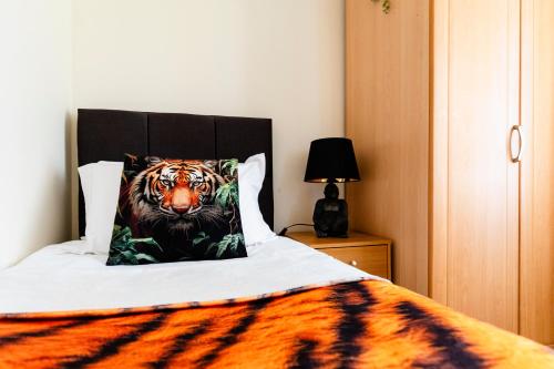 a bedroom with a tiger pillow on a bed at Jungle House in Chichester