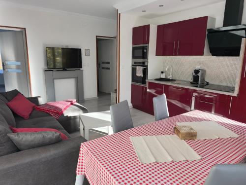 a living room with a couch and a table and a kitchen at Chez Aurel & Manu in Sainte-Marie-aux-Mines