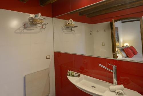 a bathroom with red walls and a sink and a mirror at Posada Verde Oliva in Maipú