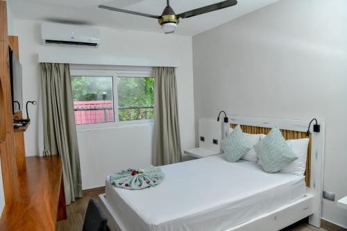 a bedroom with a white bed and a window at Honky Tonk Colonial in Santo Domingo