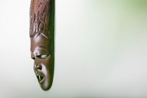 a wooden mask hanging on a wall at Jungle House in Chichester