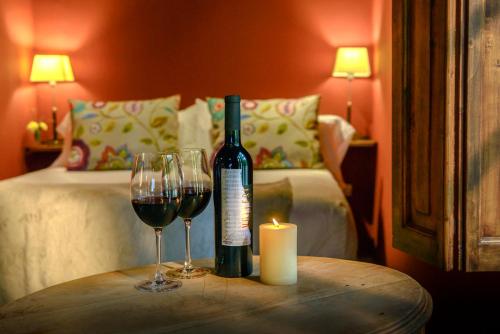 a bottle of wine and two glasses on a table at Posada Verde Oliva in Maipú
