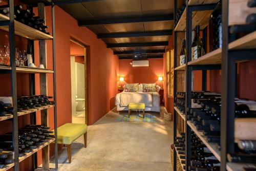 a room with a bed and a room with wine racks at Posada Verde Oliva in Maipú