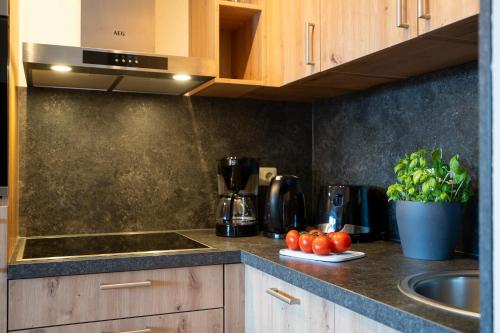 a kitchen with a sink and tomatoes on a counter at _DKK9_ Ferienwohnung Moewennest in Niendorf