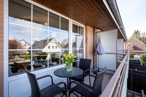 a patio with a table and chairs on a balcony at _DKK9_ Ferienwohnung Moewennest in Niendorf