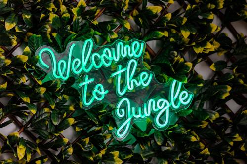 a green sign that reads welcome to the jungle at Jungle House in Chichester