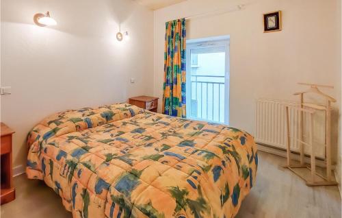 ein Schlafzimmer mit einem Bett mit einer bunten Bettdecke in der Unterkunft Amazing Apartment In Usson-En-Forez With Kitchen in Usson-en-Forez