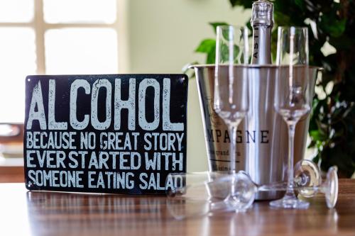 a sign on a table with a bottle of wine at Jungle House in Chichester